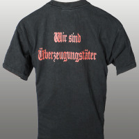 Auf dem Bild ist ein T-Shirt mit dem Aufdruck "Wir sind Überzeugungstäter" zu sehen. Auf dem Bild ist ein T-Shirt mit dem Aufdruck "Wir sind Überzeugungstäter" zu sehen.